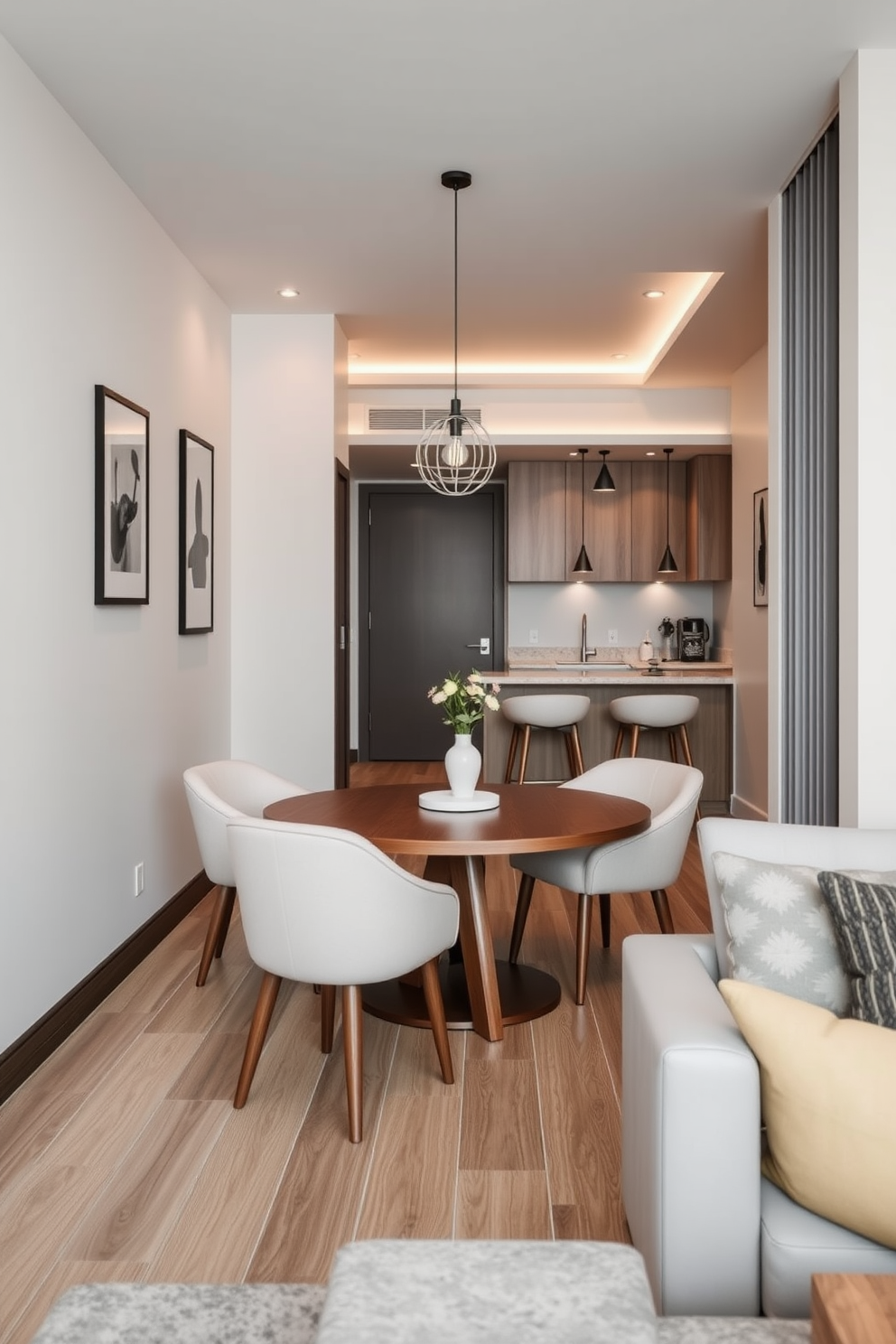 A compact dining area featuring a round wooden table surrounded by upholstered chairs in a soft pastel color. The walls are adorned with framed artwork and a pendant light hangs above the table, creating an inviting atmosphere. For the one-bedroom apartment design, envision a cozy living space that seamlessly integrates the living room and kitchen. The layout includes a stylish sofa, a small coffee table, and a compact kitchen island with bar stools, maximizing functionality while maintaining elegance.