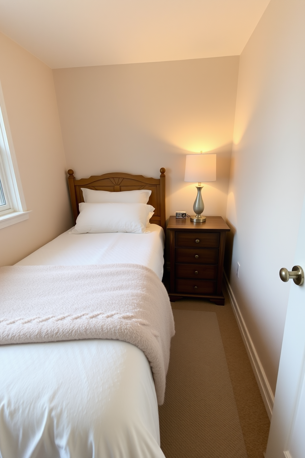 A cozy 10x10 bedroom featuring a small wooden dresser for storage positioned against one wall. The bed is dressed in soft neutral linens with a plush throw blanket, and a bedside table holds a stylish lamp for warm lighting.