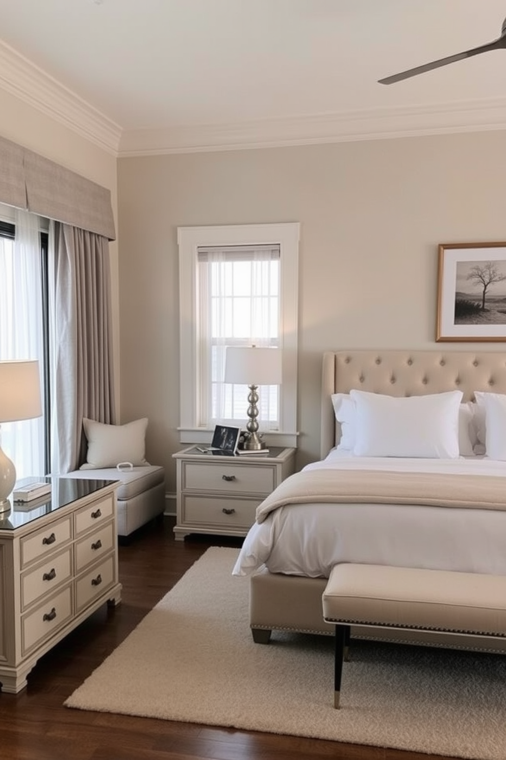 A serene bedroom retreat featuring soft beige walls and light gray accents. The space includes a plush king-sized bed with a tufted headboard and crisp white linens, complemented by matching bedside tables with elegant lamps. A cozy reading nook is positioned by a large window, adorned with sheer curtains that let in natural light. The room is finished with a soft area rug and tasteful artwork that enhances the tranquil atmosphere.