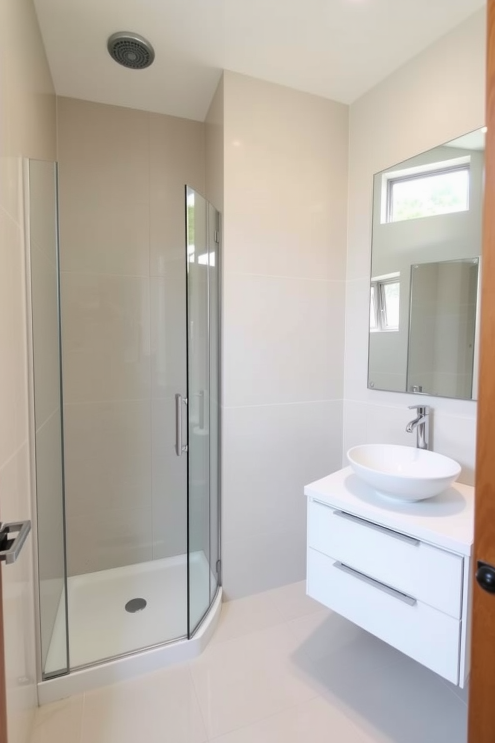 A compact shower with a sleek glass enclosure is the focal point of this 5x5 bathroom design. The walls are adorned with large-format tiles in a soft, neutral tone, creating a sense of spaciousness. Adjacent to the shower, a minimalist floating vanity features a white countertop and a stylish vessel sink. A large mirror above the vanity reflects the natural light streaming in from a small window, enhancing the airy feel of the space.