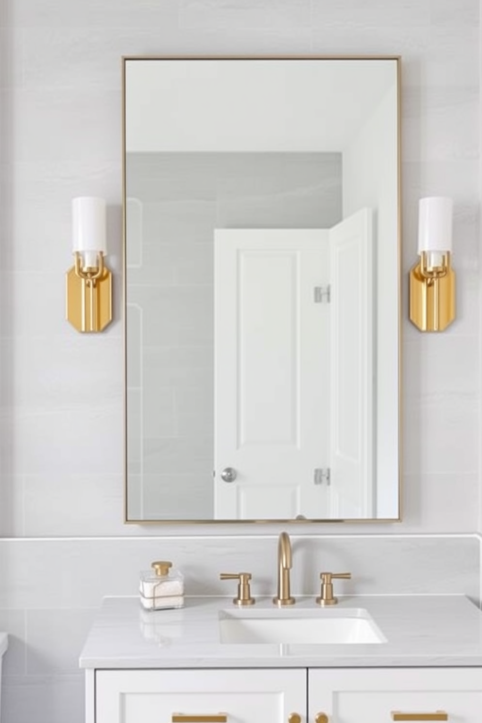 A stylish 5x5 bathroom featuring elegant sconce lighting flanking a large rectangular mirror. The walls are adorned with soft gray tiles, while a chic white vanity with gold hardware adds a touch of luxury.