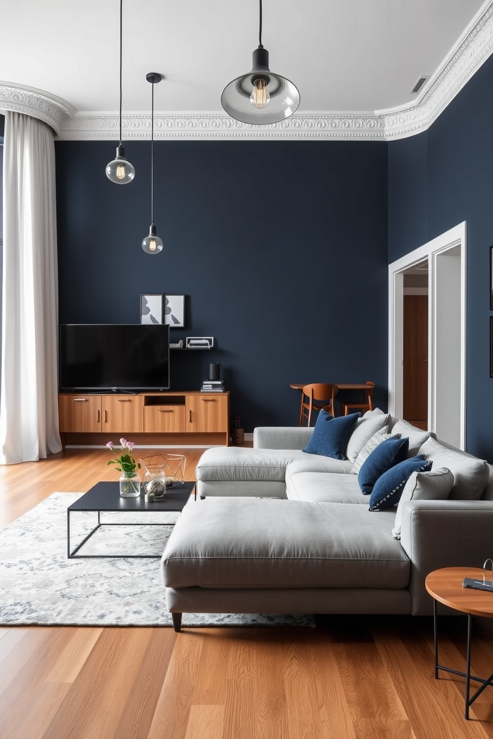 A modern apartment designed for men featuring a cohesive color scheme that promotes visual flow throughout the space. The walls are painted in a deep navy blue, complemented by light gray furniture and warm wood accents for a balanced aesthetic. The living area includes a sleek sectional sofa paired with a minimalist coffee table and a large area rug that ties the colors together. Industrial-style lighting fixtures hang from the ceiling, adding a contemporary touch while maintaining an inviting atmosphere.