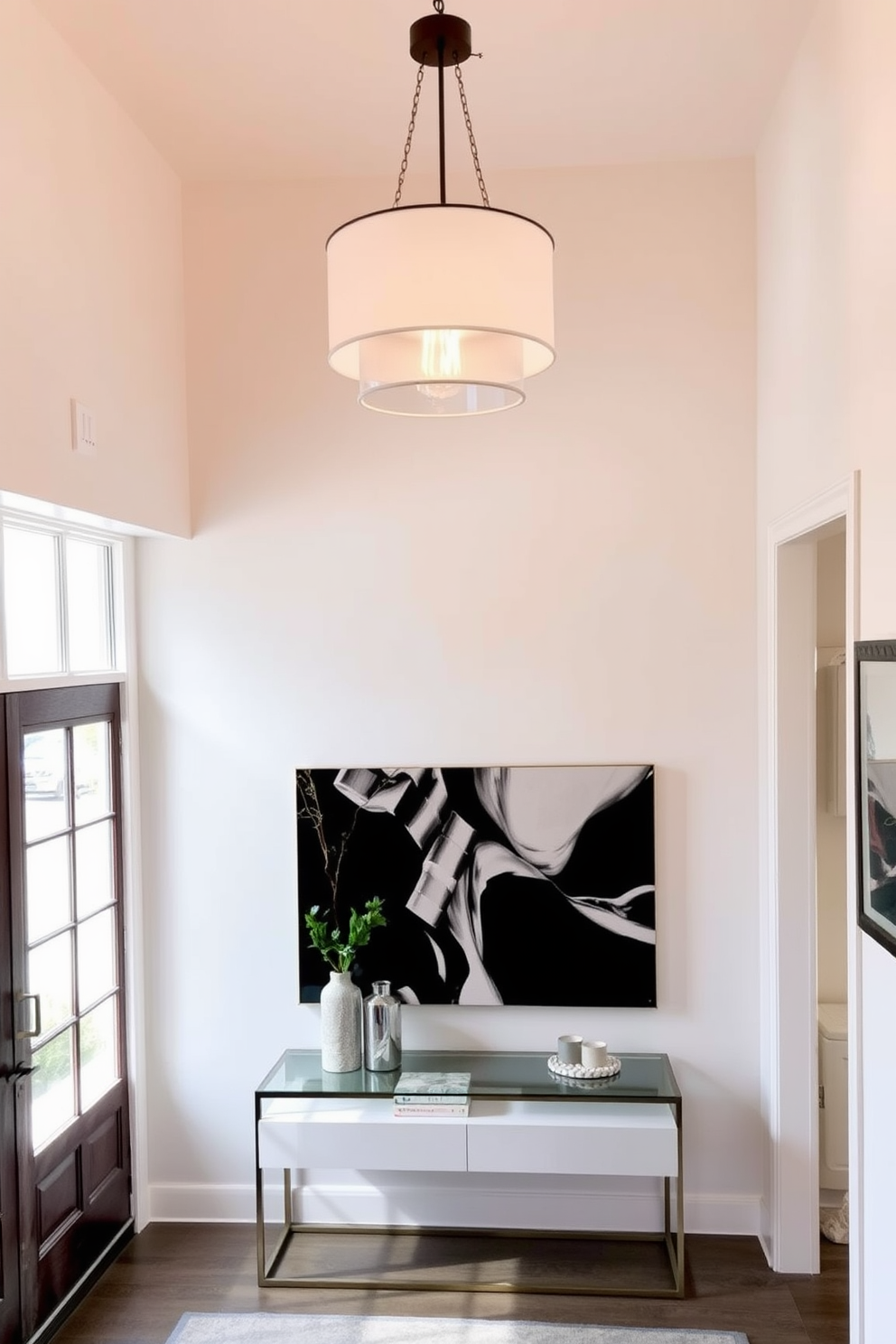 A stylish apartment entryway featuring a cohesive color palette that blends soft grays and warm beiges. The walls are adorned with minimalist art pieces, and a sleek console table sits against the wall, topped with decorative items and a small potted plant. The floor is finished with light wood planks, complemented by a plush area rug that adds texture. A statement mirror hangs above the console, reflecting natural light from a nearby window, creating an inviting atmosphere.