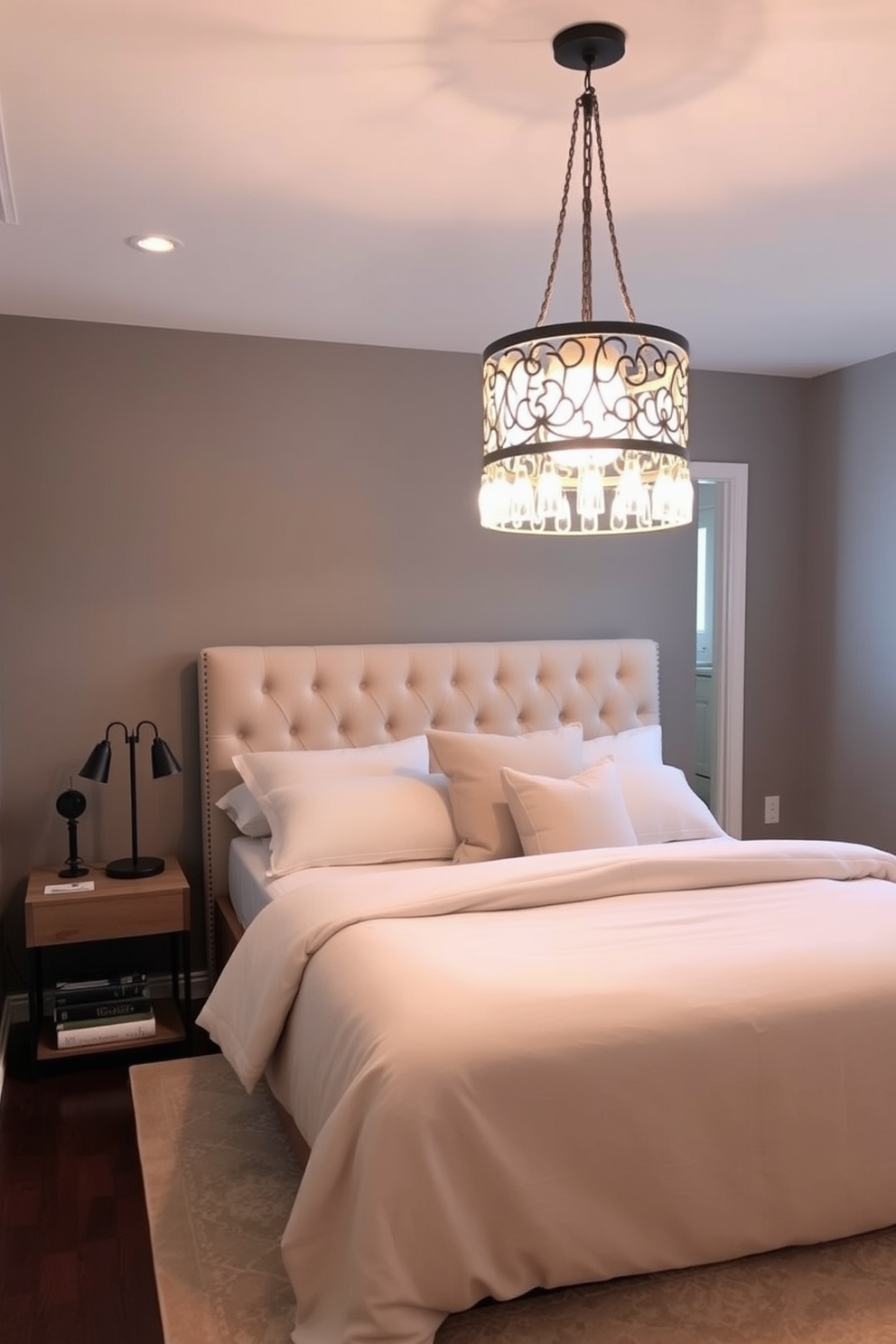 A cozy basement bedroom featuring a plush queen-sized bed with a tufted headboard and soft linens in neutral tones. A statement light fixture with an intricate design hangs from the ceiling, casting a warm glow over the space. To the side of the bed, a small wooden nightstand holds a stylish lamp and a stack of books. The walls are painted in a calming gray hue, and a large area rug adds texture and warmth to the room.