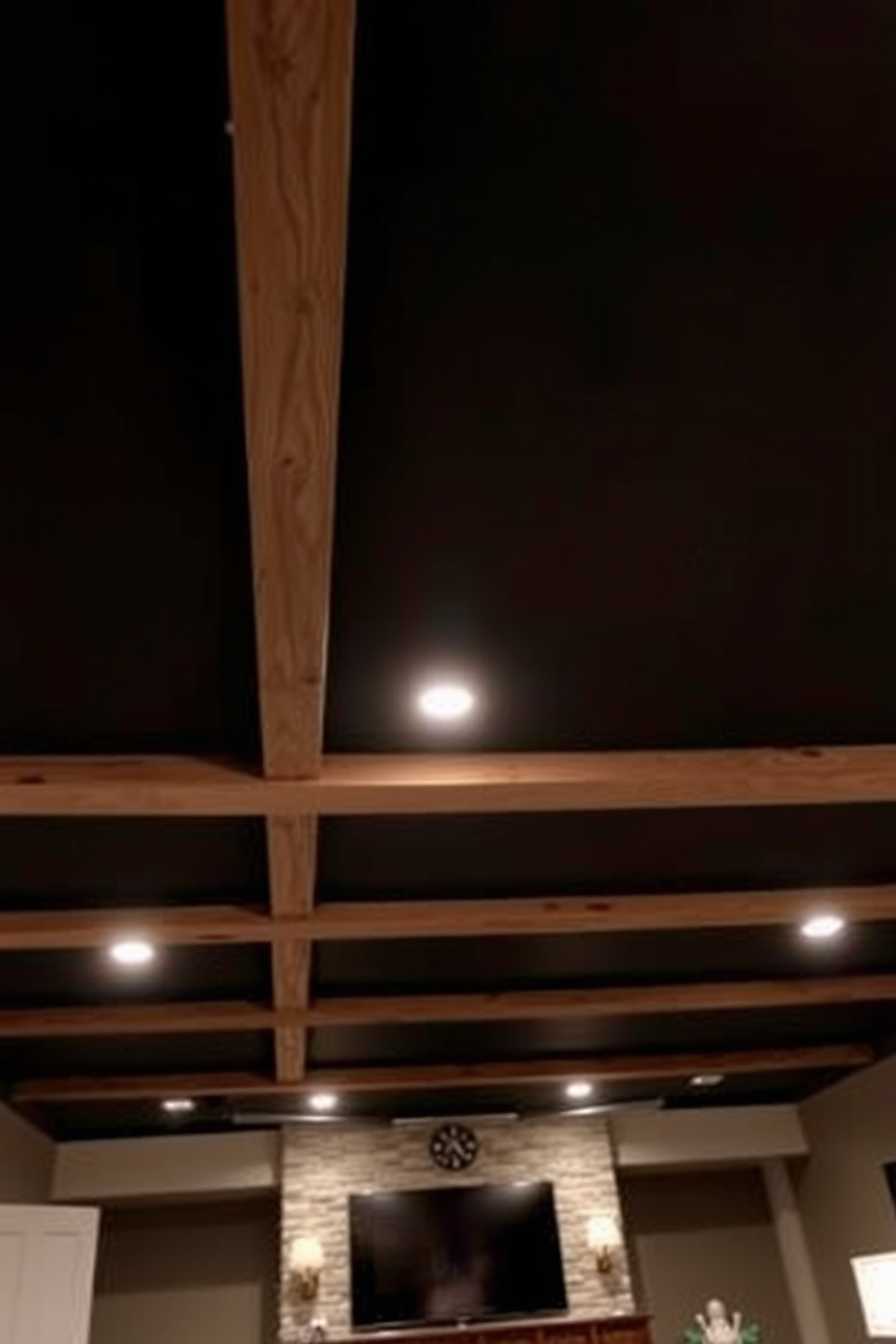 A modern basement design featuring a high ceiling with exposed wooden beams. Skylights are strategically placed to infuse the space with natural light, creating an airy and open atmosphere. The walls are painted in a soft gray tone to enhance the brightness of the room. Elegant pendant lights hang from the ceiling, adding a touch of sophistication to the overall design.