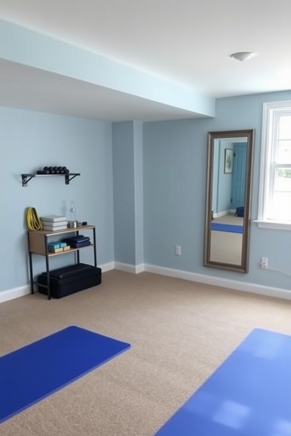 A dedicated stretching area in a basement gym features a soft, cushioned floor with large foam mats for comfort. The walls are painted in a calming light blue color, and a full-length mirror is mounted on one side to assist with form and technique. Natural light floods the space through a window, creating an inviting atmosphere. A small shelf holds yoga blocks, resistance bands, and a water bottle for convenience.