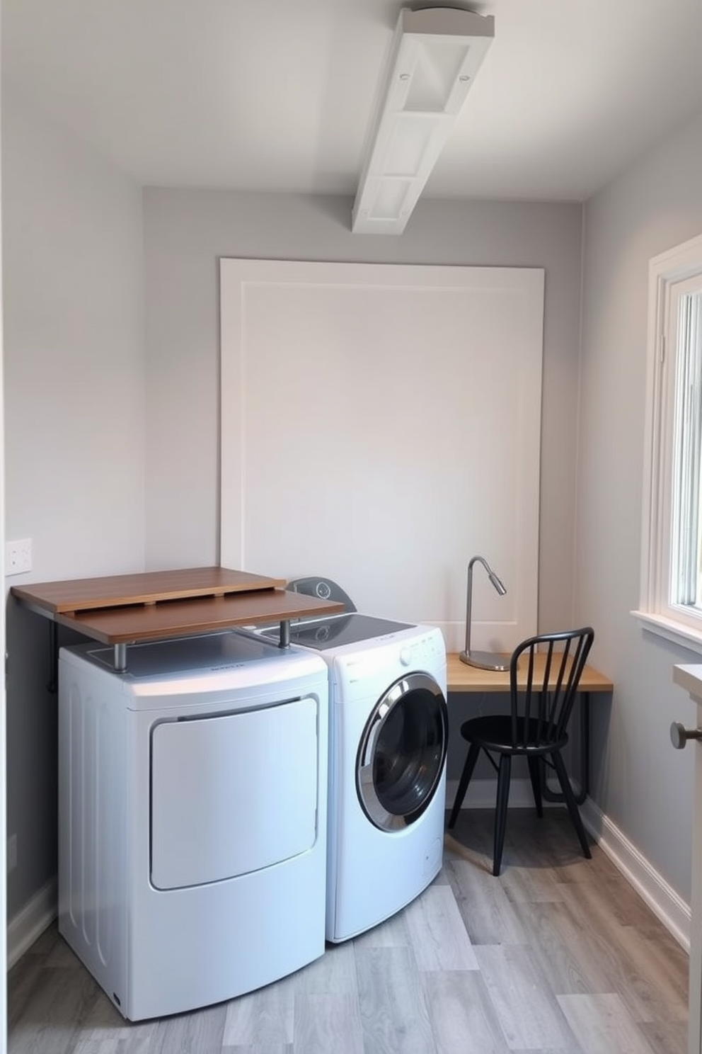 A functional basement laundry room featuring a small desk for productivity. The space includes a washer and dryer with a folding countertop above them, and the walls are painted in a light gray color to enhance brightness. To the right of the laundry appliances, there is a compact desk with a comfortable chair, perfect for managing household tasks. The floor is covered with durable vinyl flooring, and a large window allows natural light to fill the room.