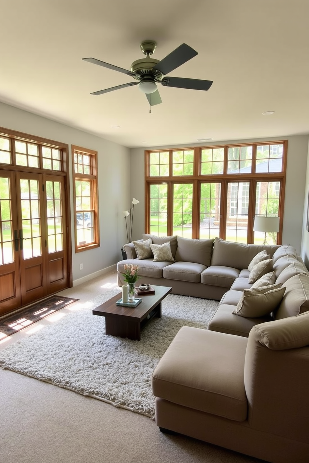 A spacious basement living room filled with natural light from large windows that open to the outdoors. The room features a cozy sectional sofa in a neutral tone, complemented by a wooden coffee table and a plush area rug.