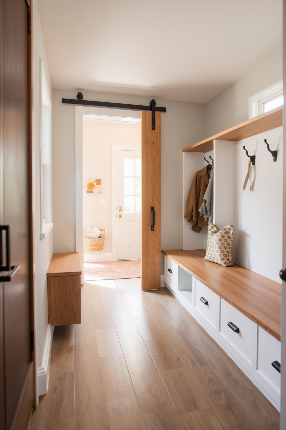 A cozy mudroom featuring a sliding barn door that opens to a spacious entryway. The room is designed with built-in storage benches and hooks for coats, creating an organized and welcoming atmosphere. Natural light floods in through a window, illuminating the warm wood tones and soft color palette. Durable flooring with a textured finish complements the overall aesthetic while ensuring practicality for daily use.