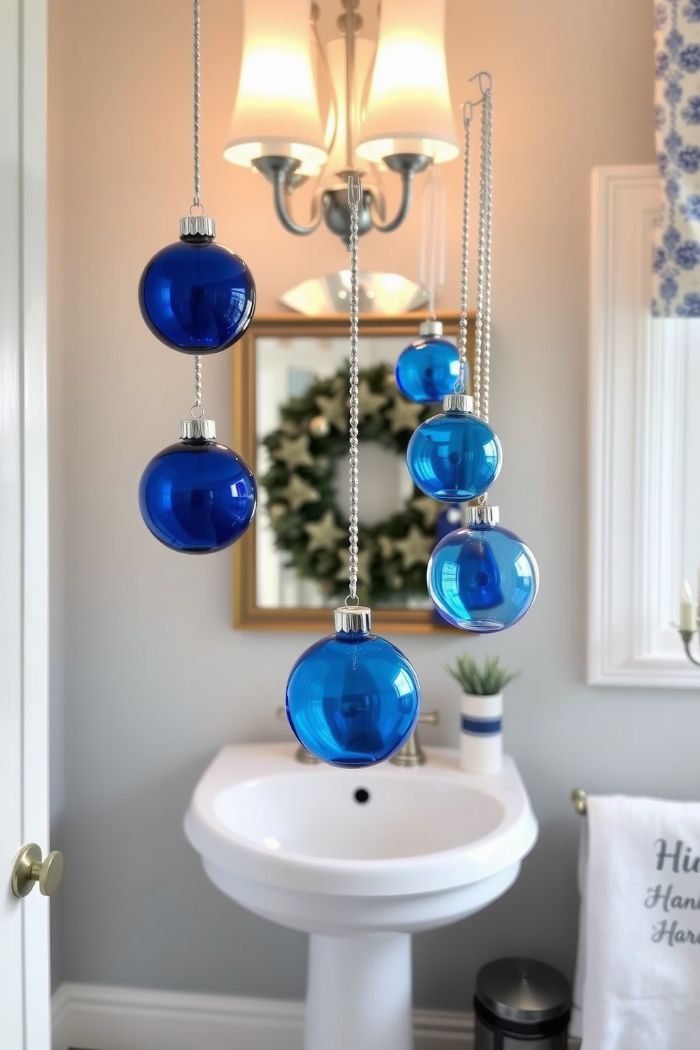 Themed candles in unique holders create a warm and inviting atmosphere. The candles are arranged on a decorative tray, showcasing various shapes and sizes, with holders made of ceramic and glass. The bathroom is elegantly decorated for Hanukkah with blue and silver accents. A menorah sits on the countertop, surrounded by festive decor and soft lighting that enhances the holiday spirit.