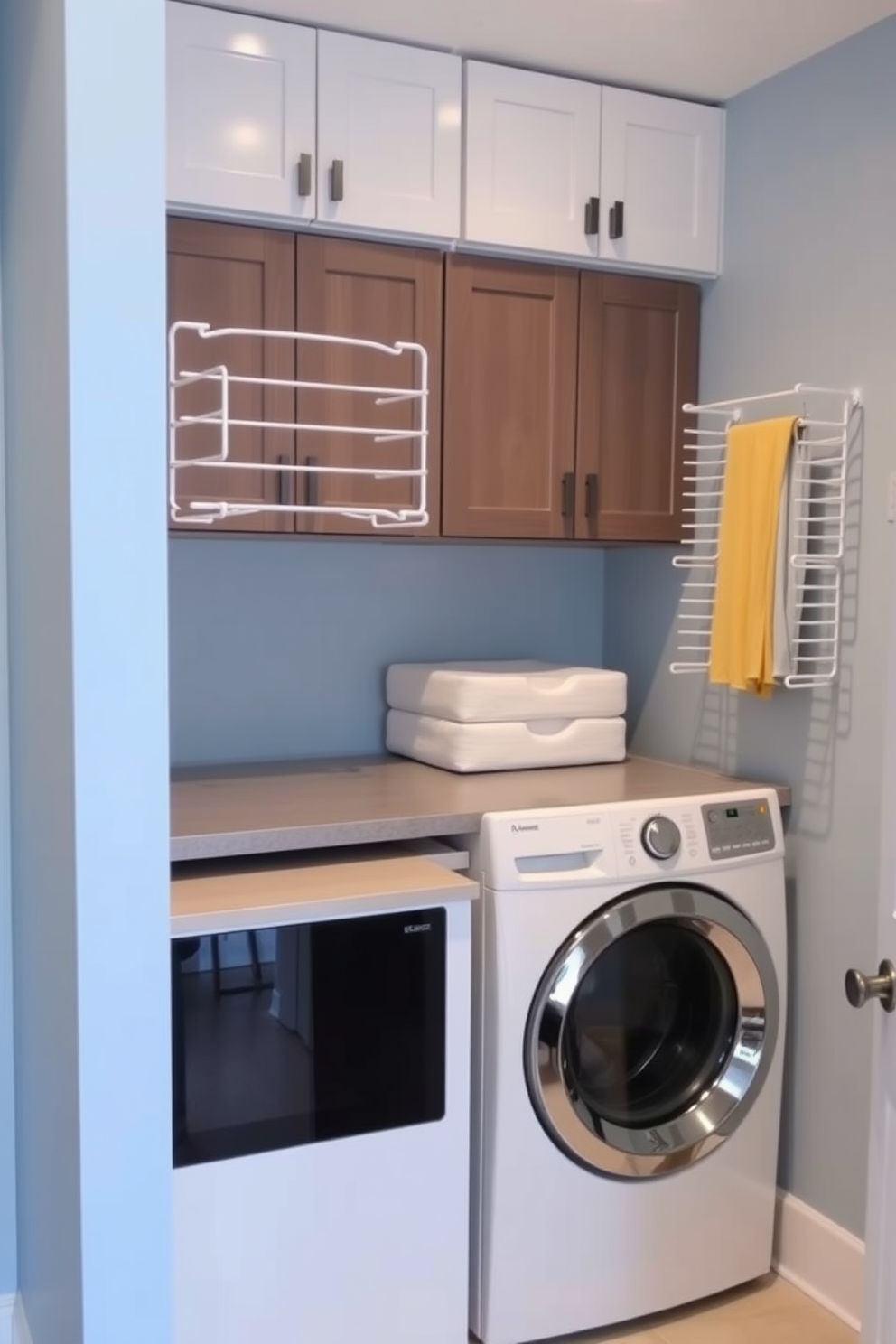 A functional laundry room featuring wall-mounted drying racks for convenience. The space includes a compact washer and dryer combo unit, with stylish cabinetry above for storage. The walls are painted in a soft blue hue, enhancing the airy feel of the room. A sleek countertop extends beside the washer and dryer, providing a workspace for folding clothes.