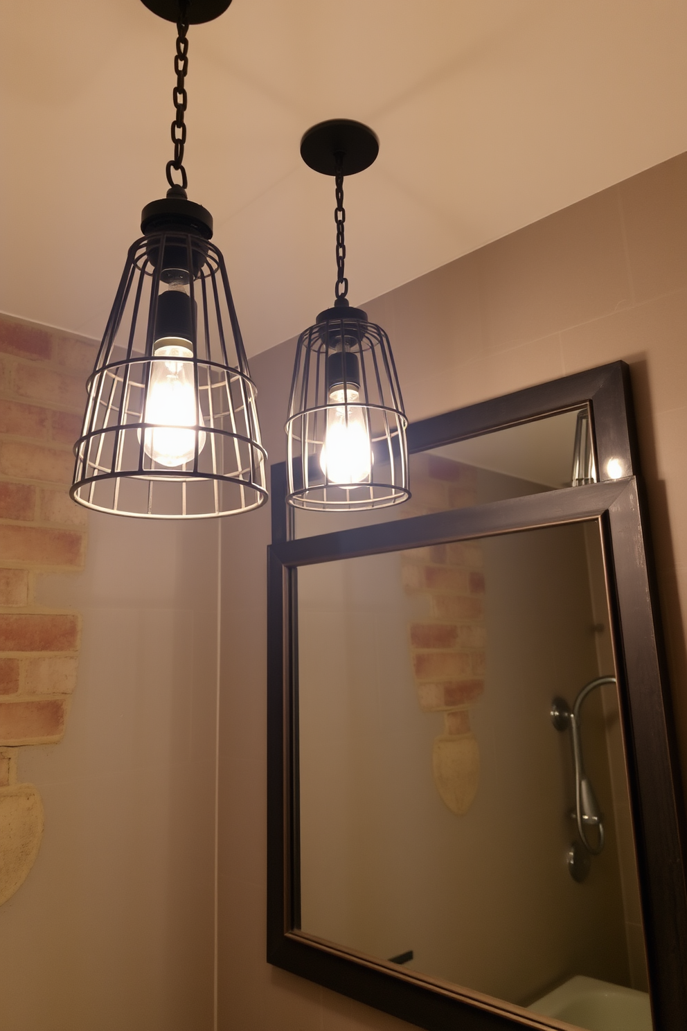 Caged light fixtures hang from the ceiling, casting a warm glow over the industrial-style bathroom. The fixtures are made of black metal, complementing the exposed brick walls and concrete flooring. A large mirror with a rugged metal frame reflects the soft light, enhancing the raw aesthetic of the space. Vintage-style bulbs illuminate the area, creating an inviting atmosphere amidst the industrial elements.