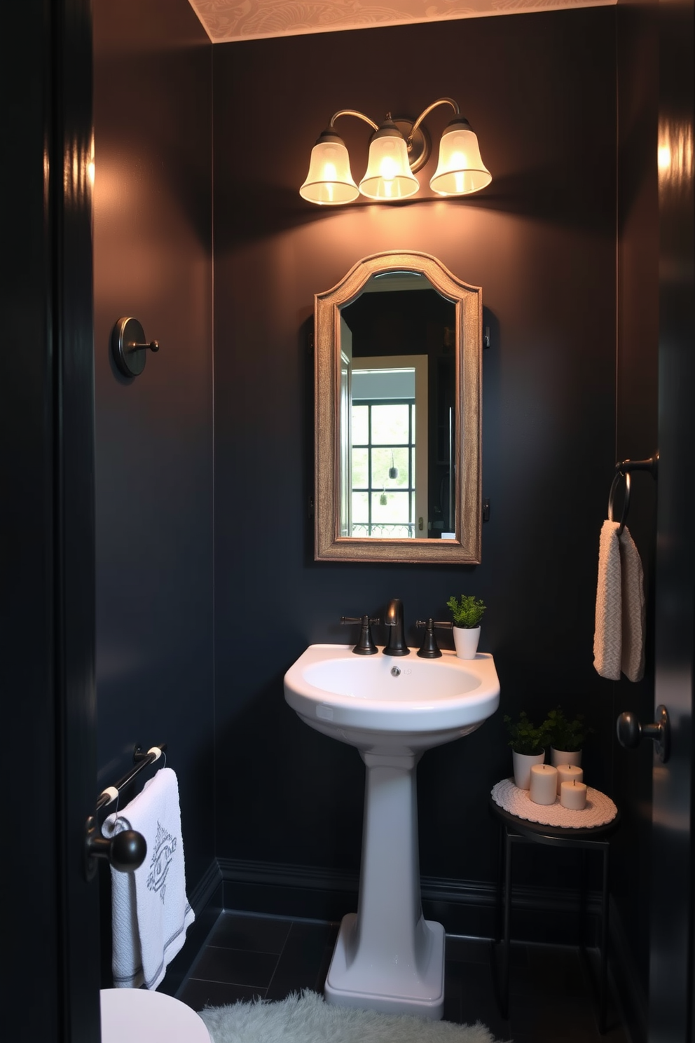 A cozy powder room featuring dark paint on the walls creates an intimate and inviting atmosphere. The space includes a stylish pedestal sink paired with a vintage mirror framed in distressed wood. Soft lighting fixtures cast a warm glow, enhancing the rich tones of the room. A plush area rug adds texture, while decorative accents like candles and small potted plants complete the inviting look.