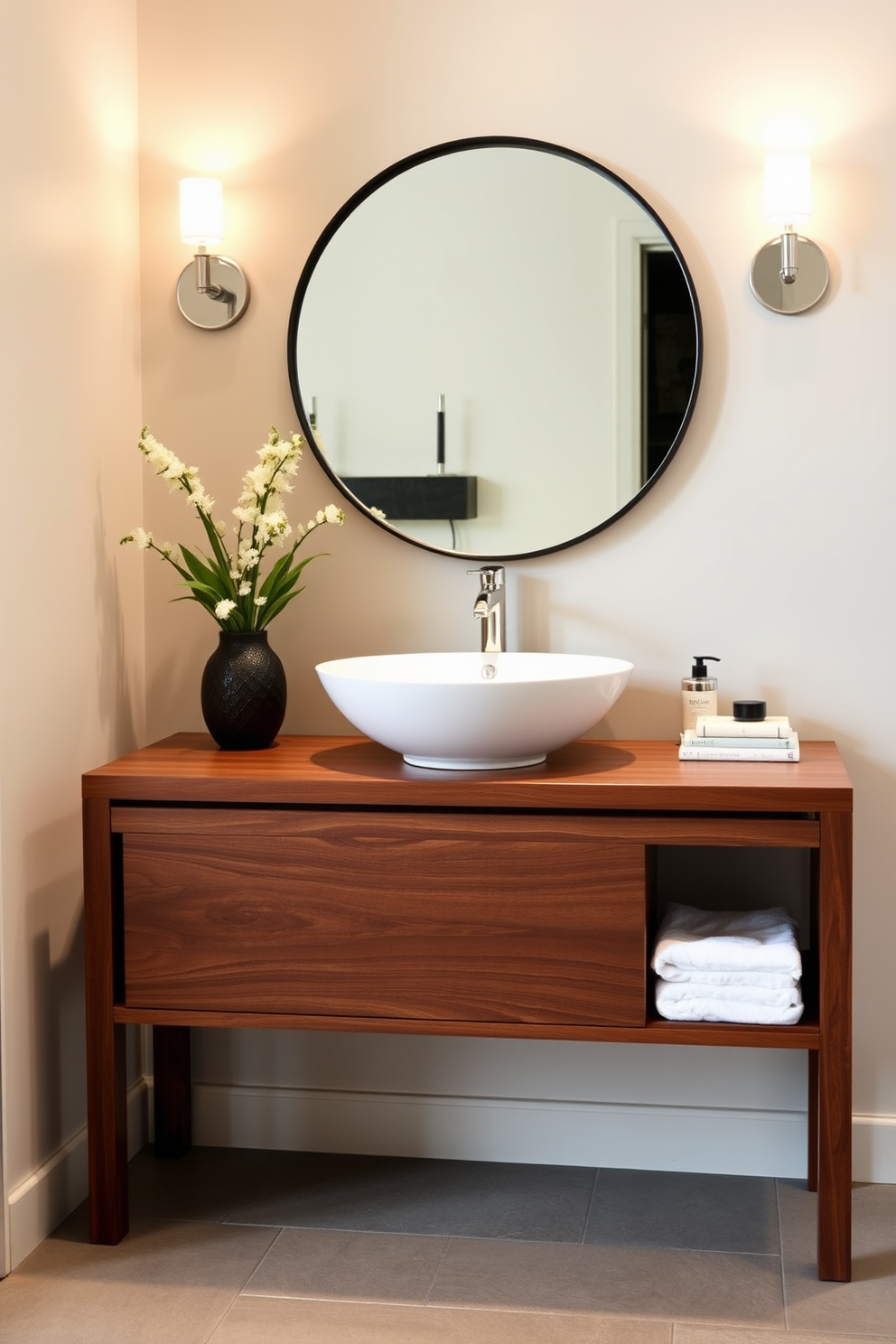 A modern vessel sink sits elegantly atop a sleek wooden console table. The console features clean lines and a rich walnut finish, complementing the contemporary design of the bathroom. Above the sink, a large round mirror with a thin black frame reflects the stylish ambiance. Soft, ambient lighting from wall sconces enhances the inviting atmosphere of the space.