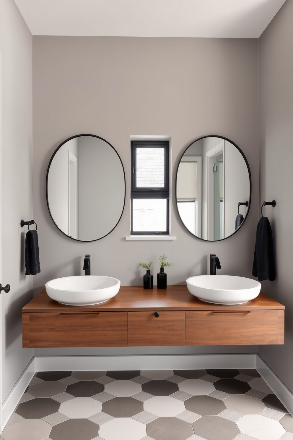 A stylish shared bathroom featuring a double sink setup with a sleek modern design. The sinks are mounted on a floating vanity made of rich walnut wood, complemented by a stunning quartz countertop. Above the sinks, two large round mirrors with minimalist black frames reflect the natural light coming through a frosted window. The walls are painted in a soft gray tone, and the floor is adorned with elegant hexagonal tiles in a contrasting color scheme.