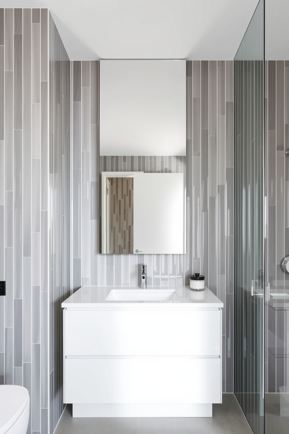 A stunning bathroom design featuring vertical stack tiles that create an illusion of height. The tiles are arranged in a sleek, modern pattern with a glossy finish, reflecting light and enhancing the spacious feel of the room. The walls are adorned with these vertical stack tiles in a soft gray hue, complemented by a minimalist white vanity. A large frameless mirror hangs above the vanity, adding depth and brightness to the overall aesthetic.