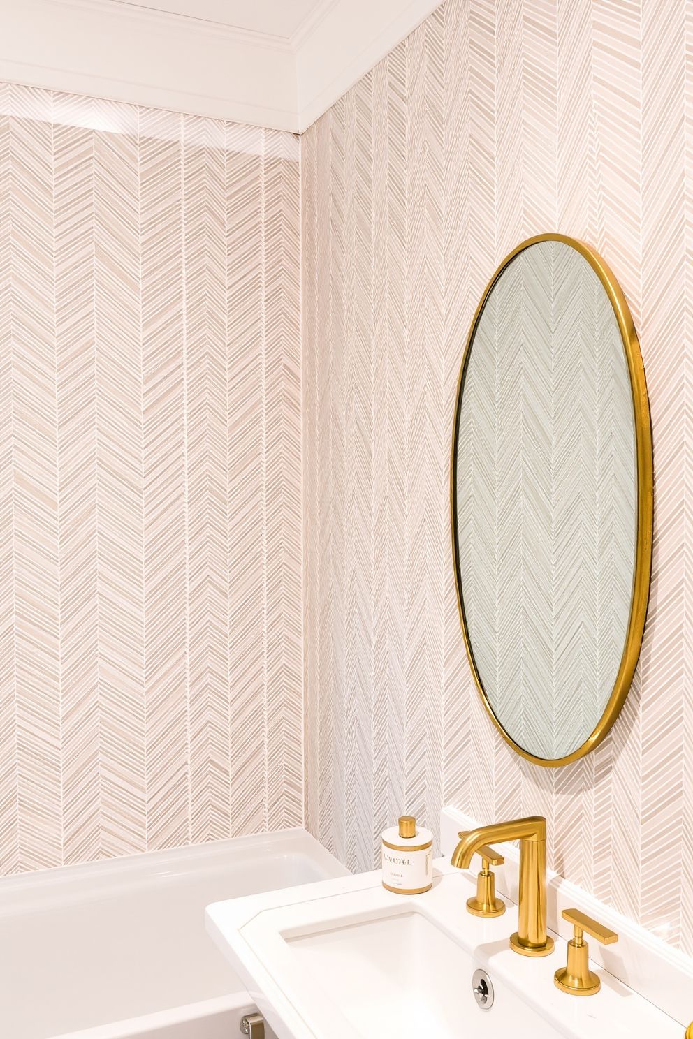 Chic herringbone patterns create an elegant backdrop for any bathroom. The wallpaper features a subtle sheen that enhances the sophistication of the space. Soft neutral tones blend seamlessly with the herringbone design, providing a calming effect. Accents of gold in the fixtures add a touch of luxury to the overall aesthetic.