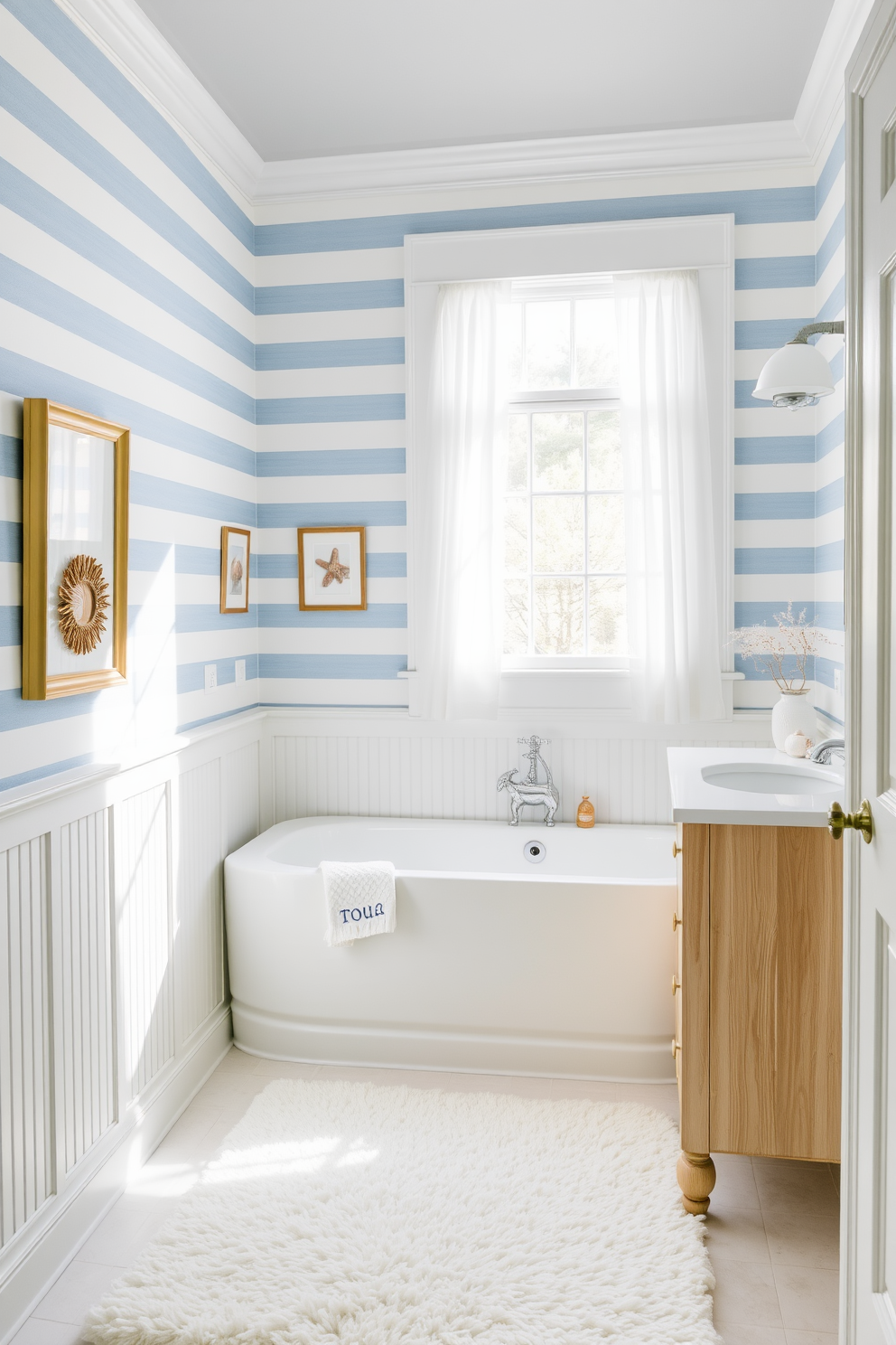 A serene bathroom featuring nautical stripes in soft blue and white, creating a refreshing coastal atmosphere. The wallpaper wraps around the room, complemented by white wainscoting and a light wood vanity. Natural light filters in through a large window adorned with sheer white curtains. Accents of coral and seashell decor enhance the seaside theme, while a plush white rug adds comfort underfoot.