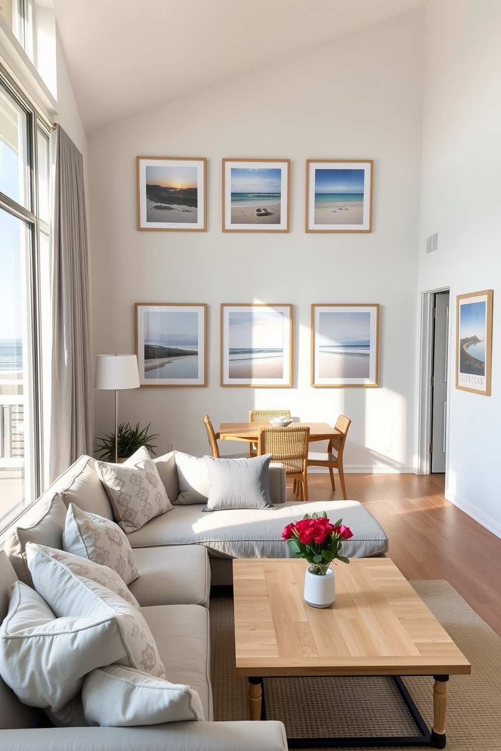 Framed beach photos adorn the walls, bringing a personal touch to the airy space. The decor features soft blues and sandy neutrals, creating a serene coastal vibe throughout the apartment. The open living area showcases a comfortable sectional sofa with plush cushions, complemented by a light wooden coffee table. Large windows allow natural light to flood in, enhancing the relaxed atmosphere and connecting the indoors with the stunning ocean view outside.