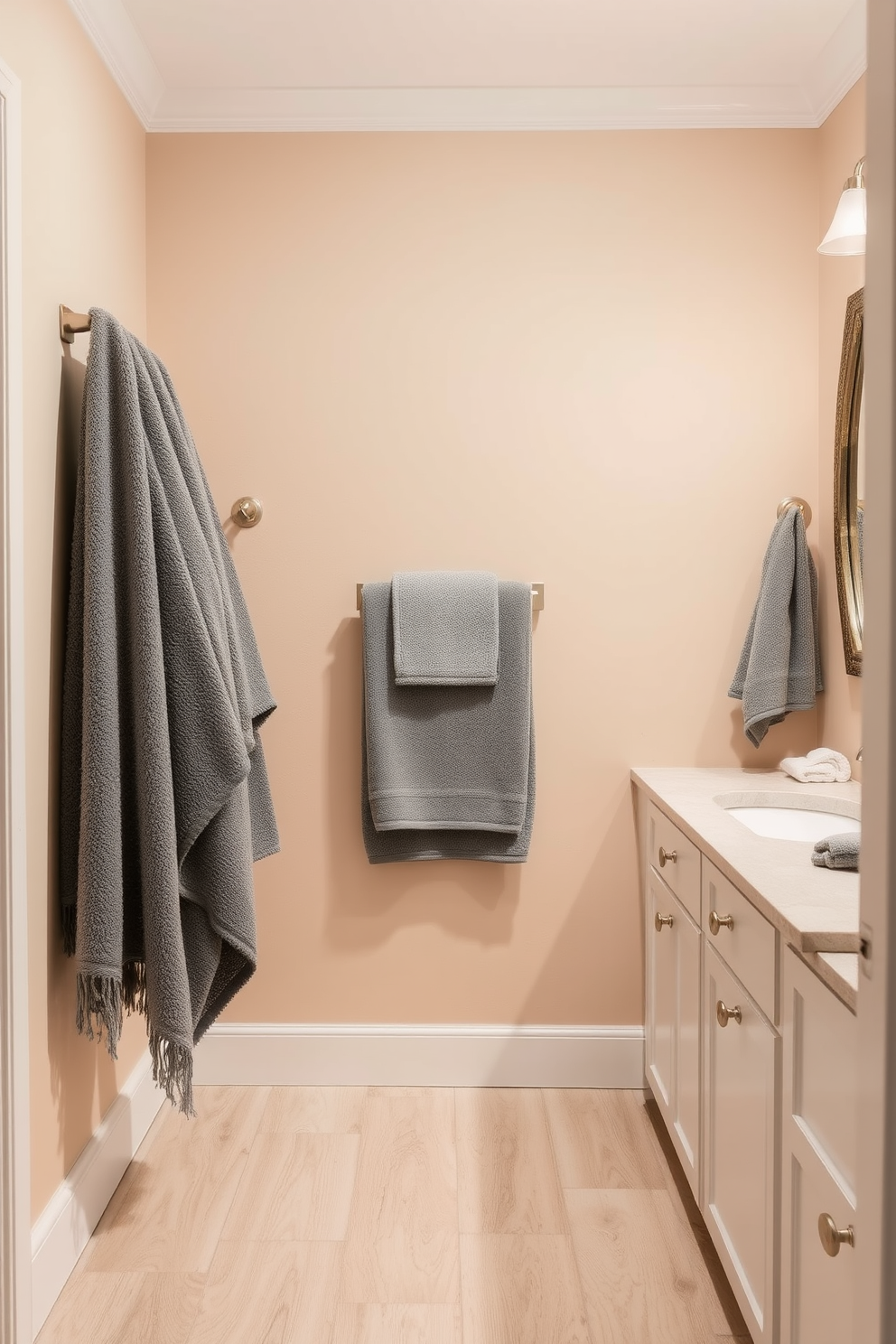 A beach bathroom design featuring luxe towels in ocean hues. The walls are painted in a soft sandy beige, and the floor is adorned with light driftwood tiles.