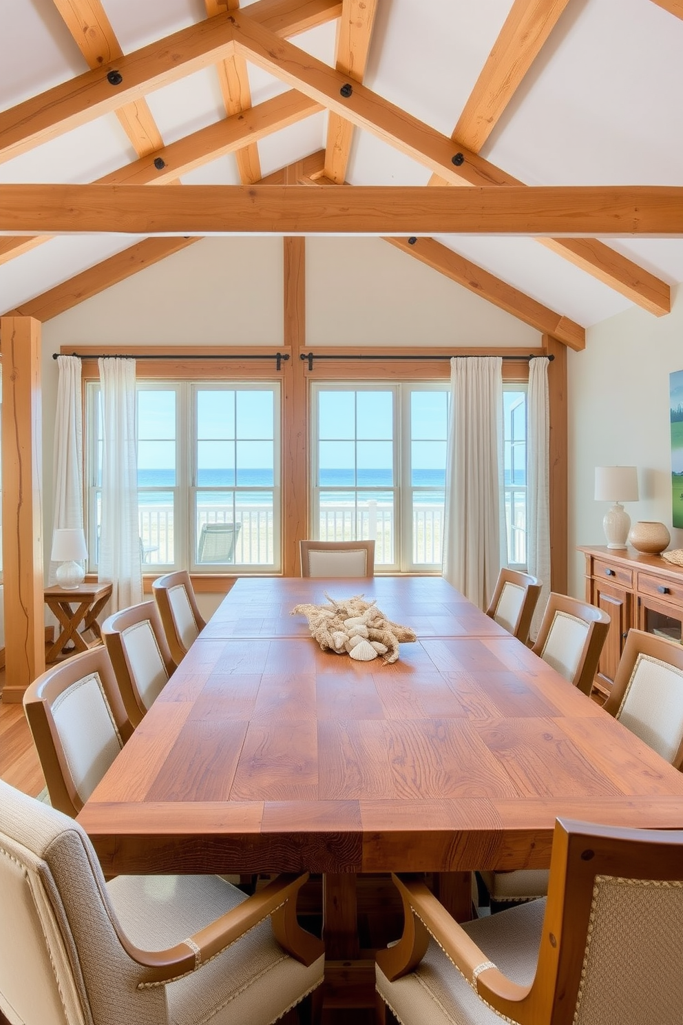 A cozy beach dining room with exposed wooden beams creating a warm and inviting atmosphere. The large dining table is made of reclaimed wood, surrounded by comfortable upholstered chairs in soft coastal colors. Natural light floods the space through large windows, showcasing views of the ocean. Decorate the table with a simple centerpiece of seashells and driftwood, complemented by light, airy curtains that flutter with the sea breeze.