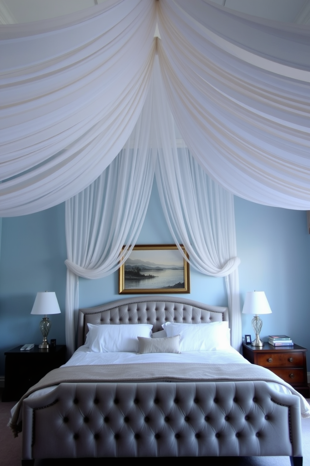 A serene bedroom setting with a fabric draped ceiling that adds softness and elegance to the space. The walls are painted in a calming light blue, and a plush king-sized bed with a tufted headboard sits center stage beneath the draped fabric.