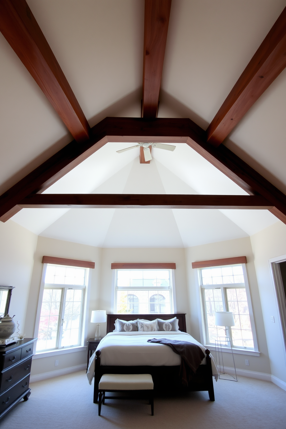 A vaulted ceiling creates an airy and spacious atmosphere in the bedroom. The design features exposed wooden beams that add warmth and character to the room. Soft, neutral paint colors enhance the height of the ceiling and promote a calming environment. Large windows allow natural light to flood in, accentuating the open feel of the space.