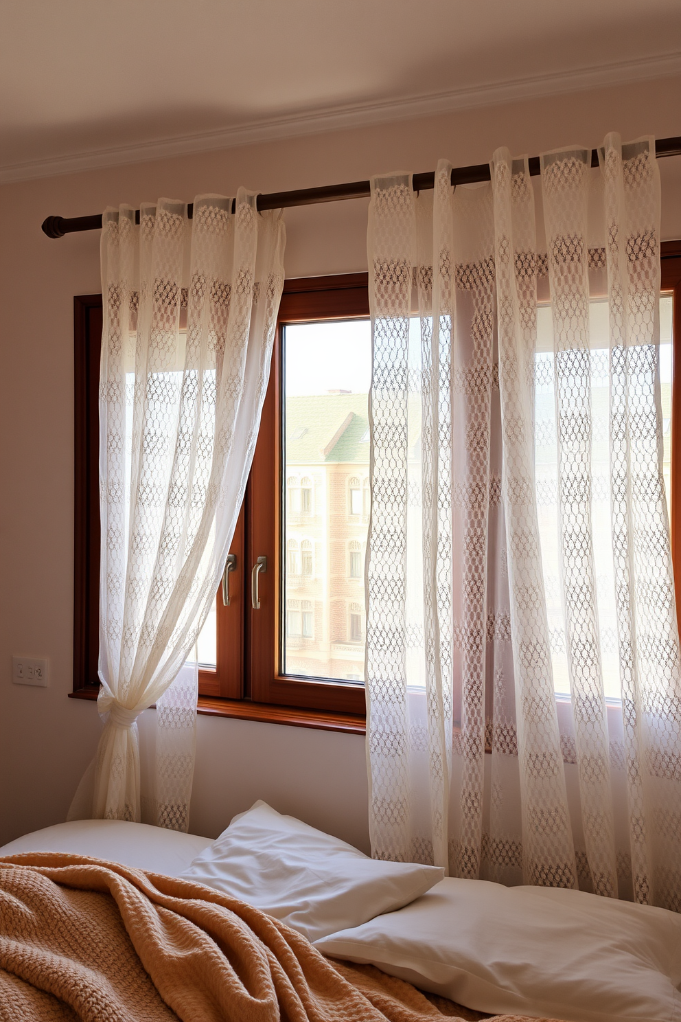 A serene bedroom setting with sheer lace curtains gently filtering the soft light. The curtains drape elegantly from a polished wooden rod, creating a romantic ambiance that enhances the cozy atmosphere of the room. The walls are painted in a soft pastel hue, complementing the delicate lace pattern of the curtains. A plush bed with fluffy pillows and a warm throw blanket sits beneath the windows, inviting relaxation and comfort.