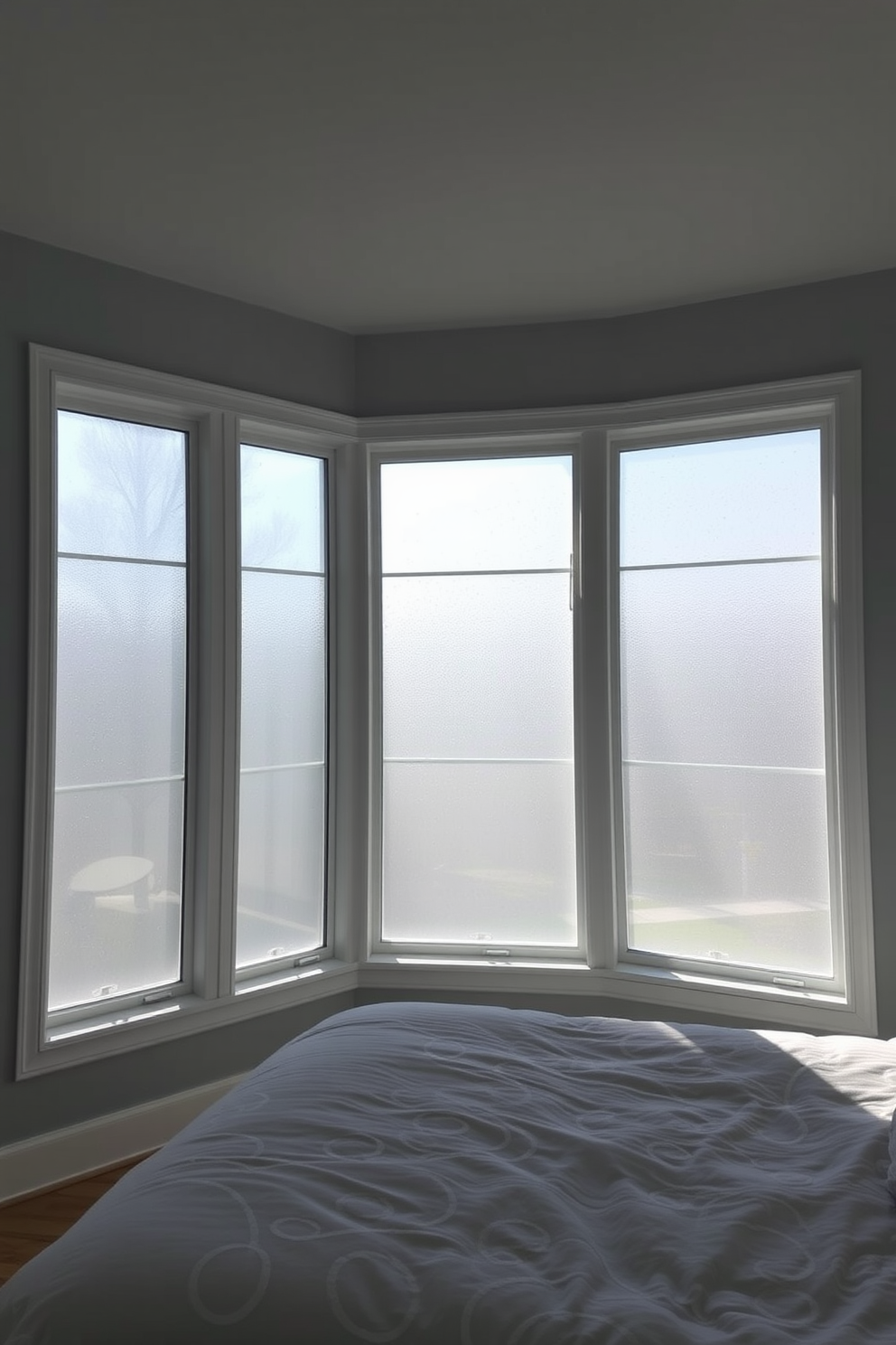 A serene bedroom featuring large frosted glass windows that provide privacy while allowing soft natural light to filter through. The windows are framed in sleek white wood, complementing the light gray walls and creating a tranquil atmosphere.