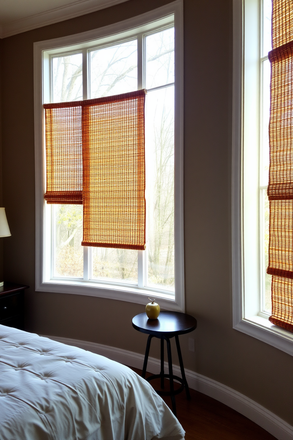 A cozy bedroom featuring large windows adorned with woven wood shades that add natural texture and warmth to the space. The soft sunlight filters through the shades, creating a serene atmosphere while complementing the neutral color palette of the room.