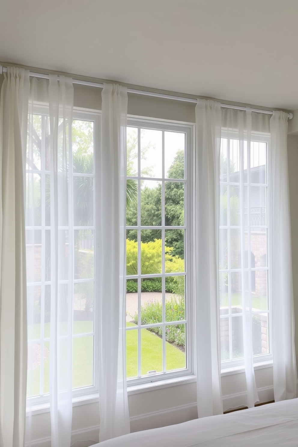 A serene bedroom setting featuring large windows adorned with sheer curtains that gently filter soft natural light. The curtains are a light, airy fabric in a soft white hue, framing the view of a lush garden outside.