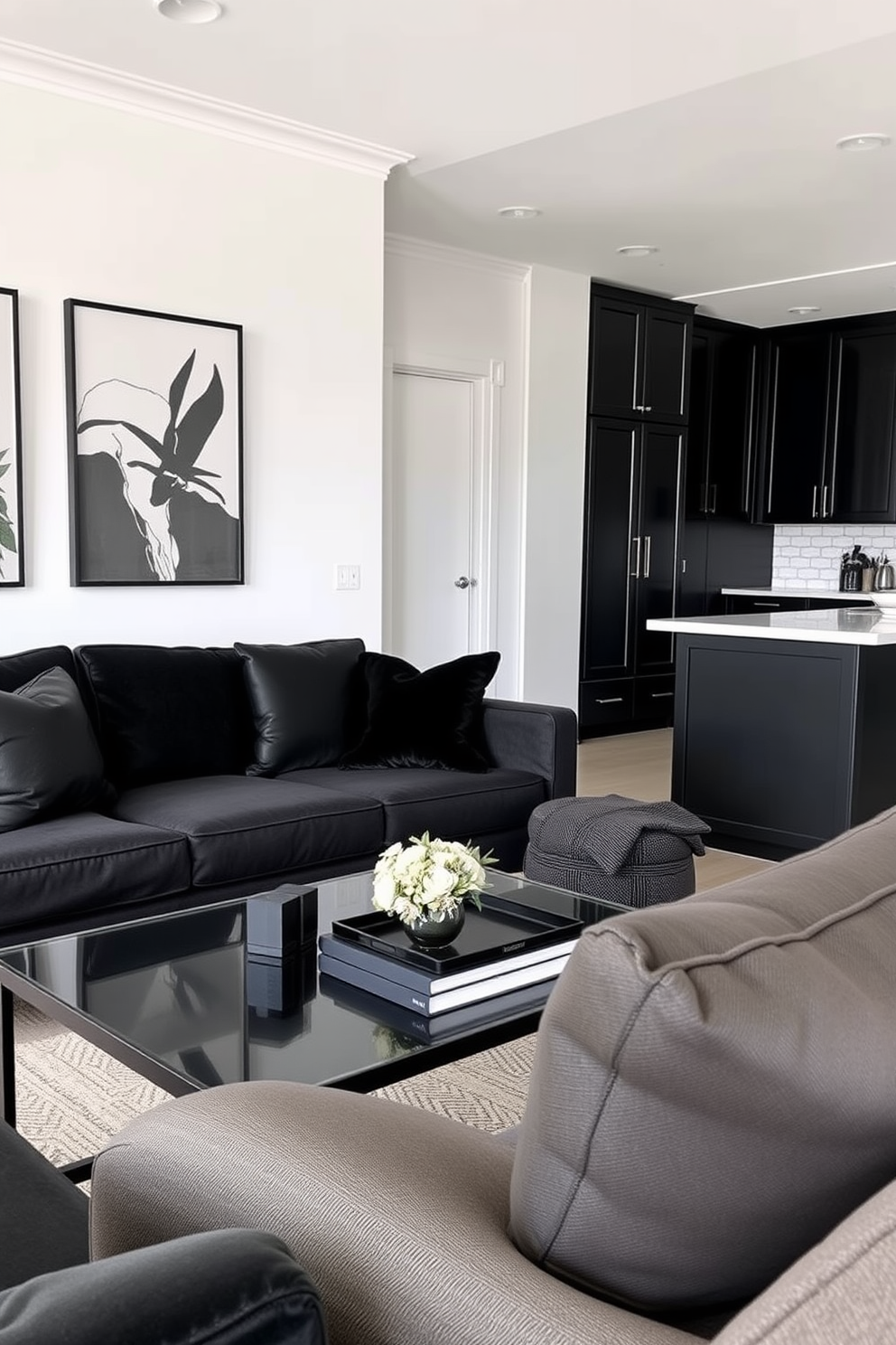 A chic living room featuring a sleek black sofa adorned with black decorative pillows that add both comfort and style. The walls are painted in a soft white, creating a striking contrast with the dark furnishings, while a modern coffee table sits in front, enhancing the sophisticated ambiance. An open-concept apartment designed with a minimalist approach, showcasing a blend of black and neutral tones. The kitchen features black cabinetry paired with brass hardware, seamlessly flowing into the living area that is accentuated by carefully placed black decorative pillows on the sofa.