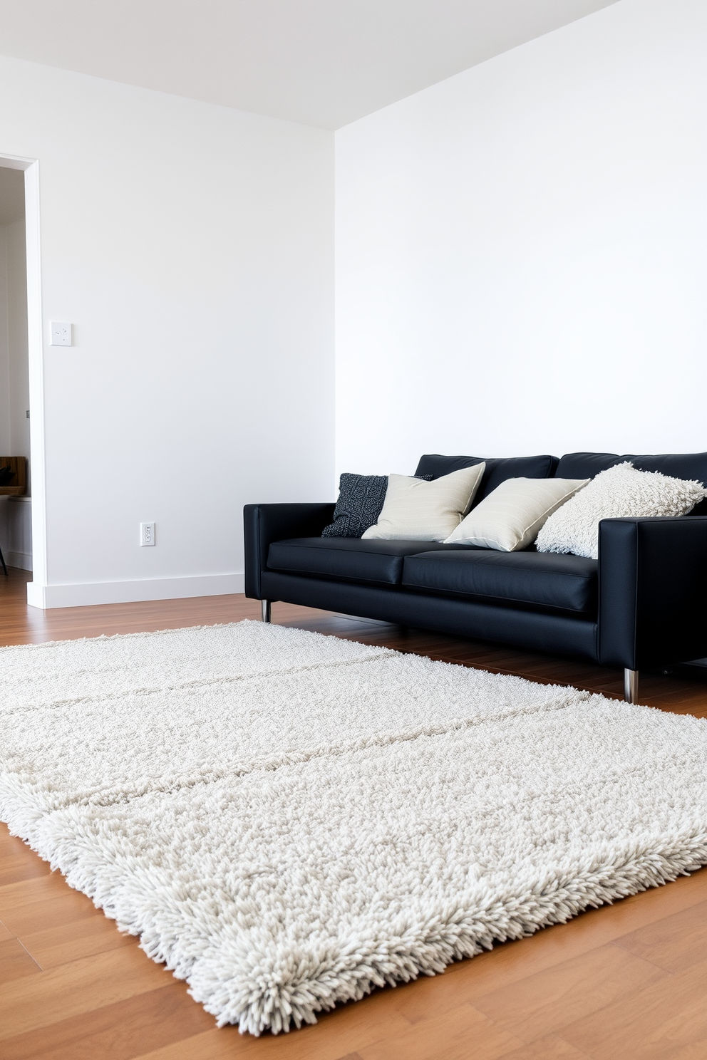 A plush area rug lies at the center of the living room, providing a soft and inviting surface underfoot. The rug features a subtle pattern that complements the overall color scheme of the space. A sleek black couch is positioned against the wall, creating a striking contrast with the light-colored walls. Stylish throw pillows in various textures and colors are arranged on the couch, adding depth and interest to the design.