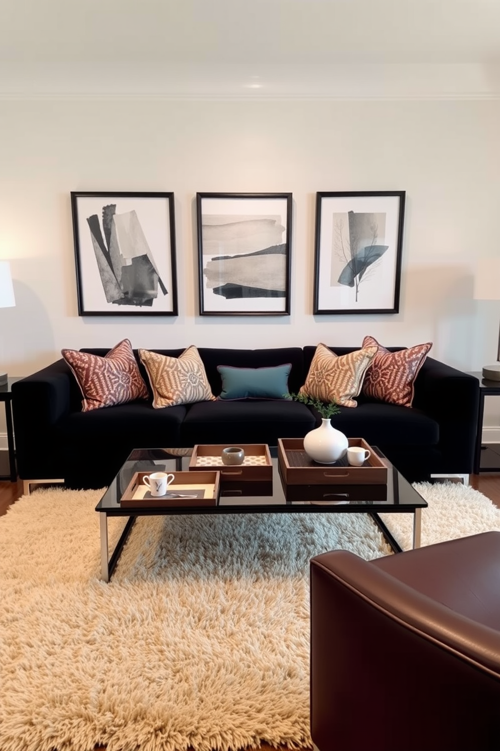 A stylish living room featuring a black couch as the focal point. The couch is adorned with colorful throw pillows and is positioned in front of a sleek coffee table topped with decorative trays for organized styling. The walls are painted in a soft neutral tone, creating a warm and inviting atmosphere. A plush area rug anchors the seating area, while modern art pieces hang above the couch, adding a touch of sophistication.