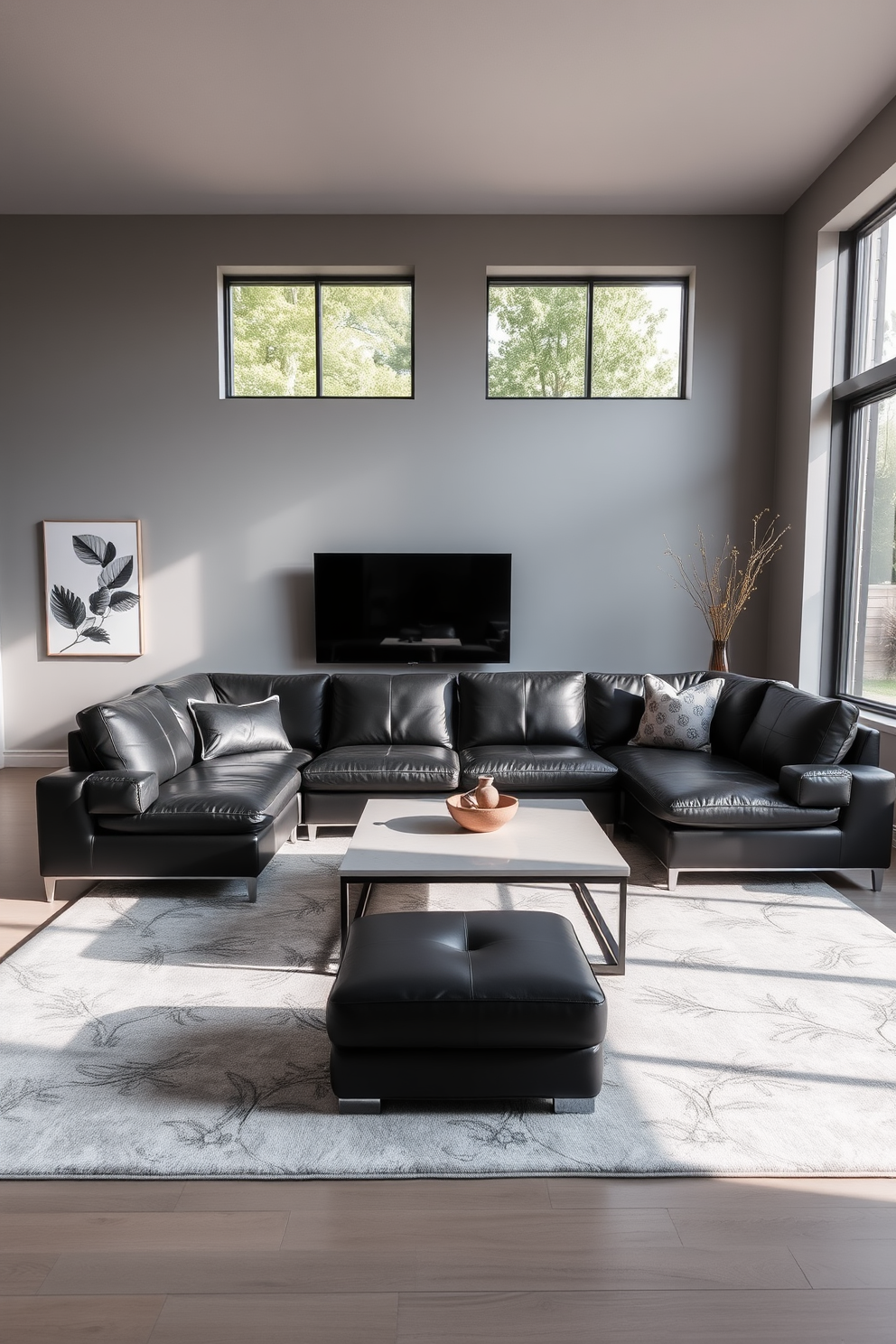 A sleek black leather sectional sofa is positioned in a modern family room. The space features a large area rug in a neutral tone, complemented by a minimalist coffee table in front of the sofa. The walls are painted in a soft gray, enhancing the contemporary feel of the room. Large windows allow natural light to flood in, creating a warm and inviting atmosphere.