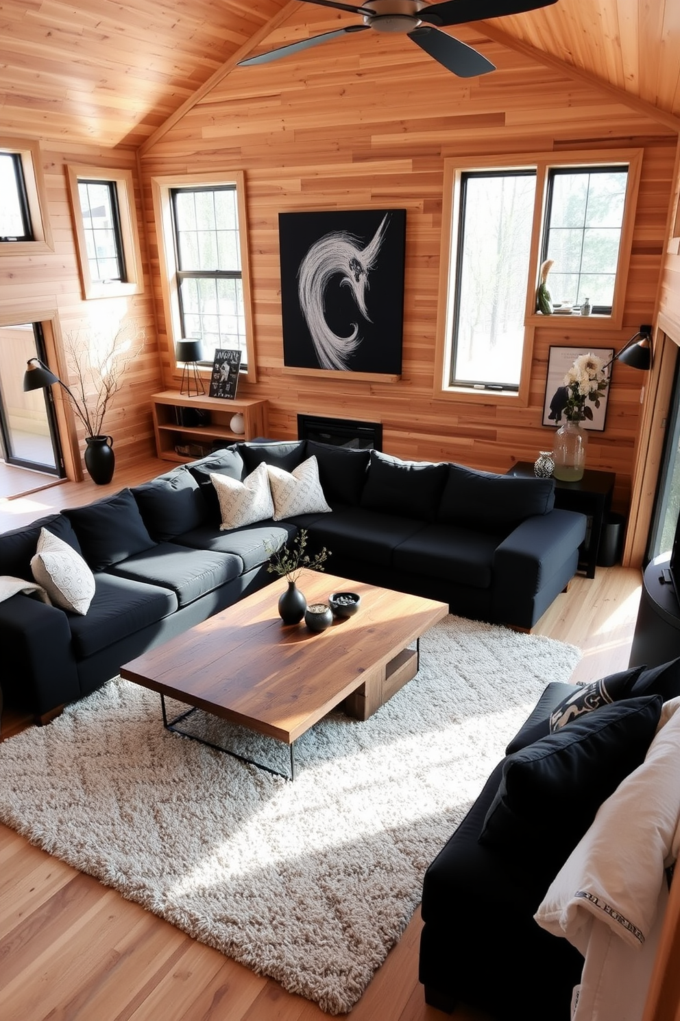 A cozy family room featuring natural wood elements and sleek black decor. The walls are adorned with wooden panels, and a large black sectional sofa is positioned in the center of the space. A rustic coffee table made of reclaimed wood sits atop a plush area rug. Floor-to-ceiling windows allow natural light to flood the room, highlighting the contrast between the warm wood tones and the modern black accents.