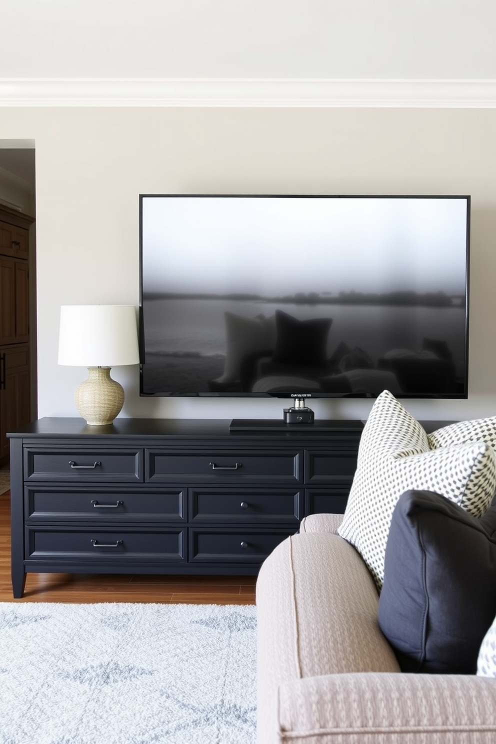 A striking black framed artwork gallery wall serves as the focal point of the family room. The wall features an eclectic mix of abstract and landscape pieces in varying sizes, creating a dynamic visual impact. The family room is designed with plush seating in rich fabrics, complemented by a sleek coffee table at the center. Warm lighting from stylish floor lamps enhances the inviting atmosphere, making it perfect for relaxation and gatherings.