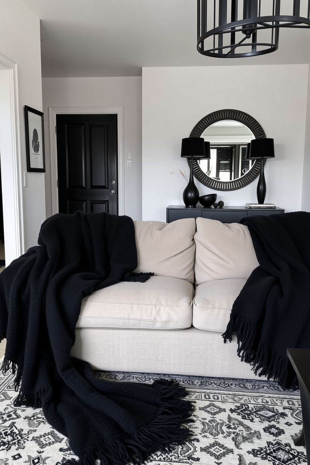 Cozy black throw blankets are draped over a plush sofa, inviting relaxation and warmth. The room features a modern foyer with sleek black accents, including a stylish console table and a statement mirror. The walls are painted in a soft white, creating a striking contrast with the black elements. A decorative rug with intricate patterns adds texture and comfort to the space, enhancing the overall cozy atmosphere.