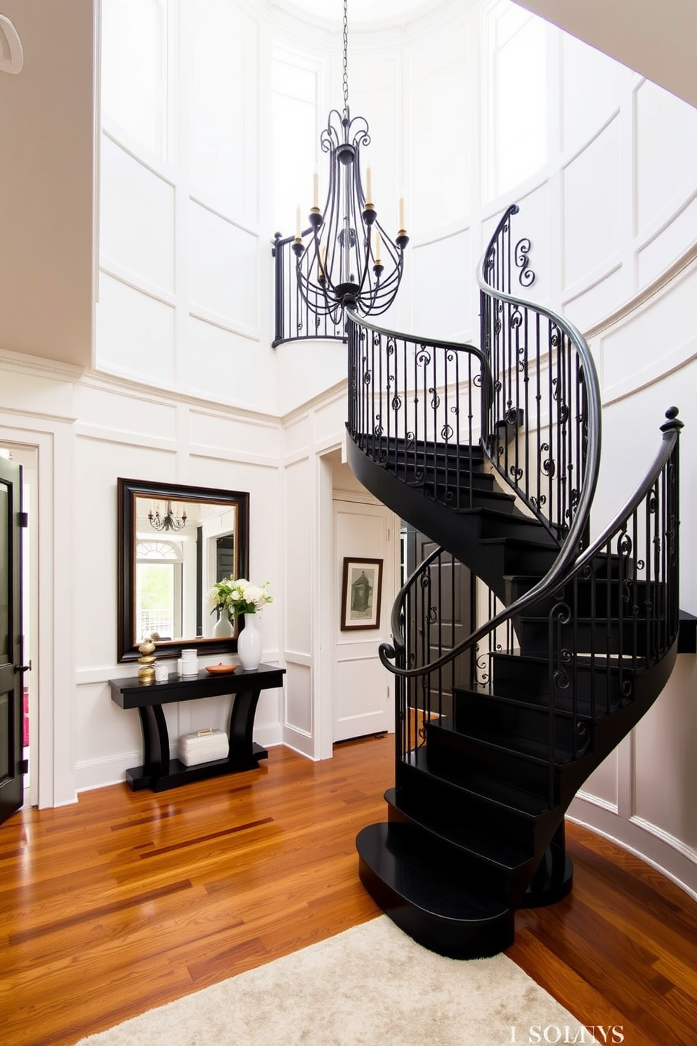 A bold black staircase with an elegant wrought iron railing spirals gracefully upwards, creating a striking focal point in the foyer. The walls are adorned with soft white paneling, contrasting beautifully with the dark staircase, while a large chandelier hangs from the ceiling, casting a warm glow over the space. The foyer features a sleek console table against one wall, topped with decorative items and a large mirror that reflects the grandeur of the staircase. Rich hardwood flooring adds warmth to the space, complemented by a plush area rug that invites guests to step inside.