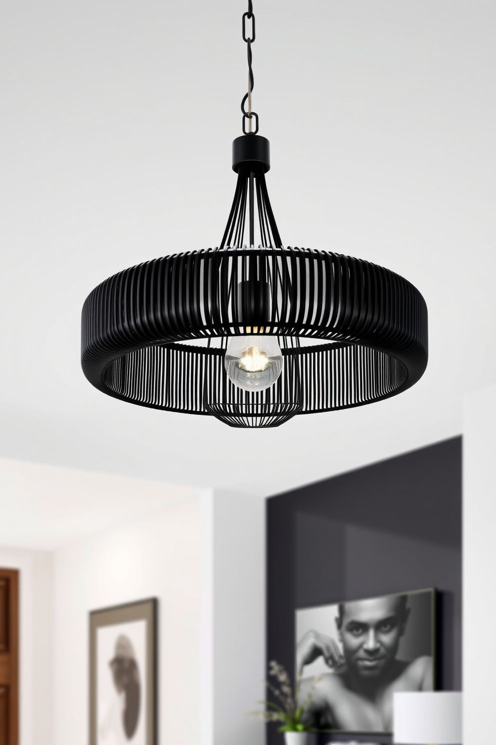 A modern black pendant light fixture hangs elegantly above a sleek foyer space. The foyer features minimalist decor with a black accent wall, creating a striking contrast with the light fixture's design.