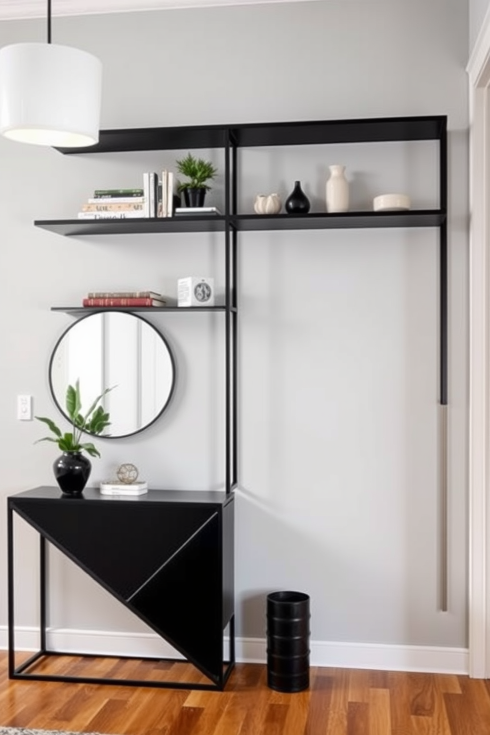 A minimalist black shelving unit is mounted against a light gray wall, showcasing an array of carefully curated decor items. The shelves are styled with a mix of books, small plants, and artistic sculptures, creating a clean and modern aesthetic. The foyer features a sleek black console table with a geometric design, paired with a large round mirror above it. Soft lighting from a contemporary pendant light illuminates the space, enhancing the warm wood flooring and inviting atmosphere.