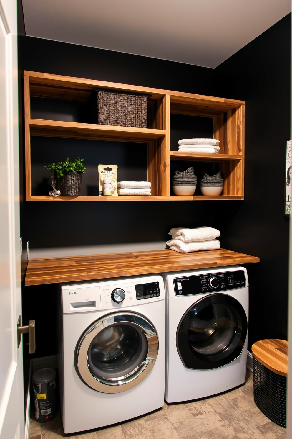 A modern laundry room featuring open shelving for stylish storage solutions. The shelves are made of reclaimed wood and are adorned with neatly arranged baskets and decorative boxes. The walls are painted in a sleek black hue, creating a dramatic backdrop for the space. A minimalist countertop extends beneath the shelves, providing ample workspace for laundry tasks.