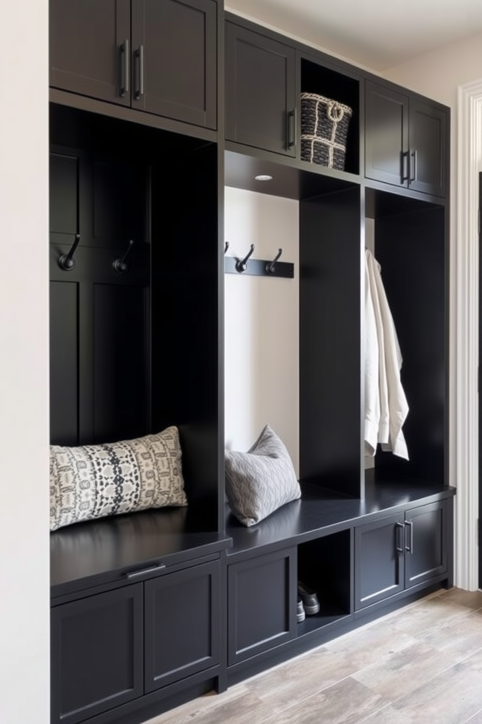 A textured black accent wall features stylish hooks for hanging coats and bags. The mudroom is designed with a sleek bench for seating and storage, complemented by a warm wood floor.