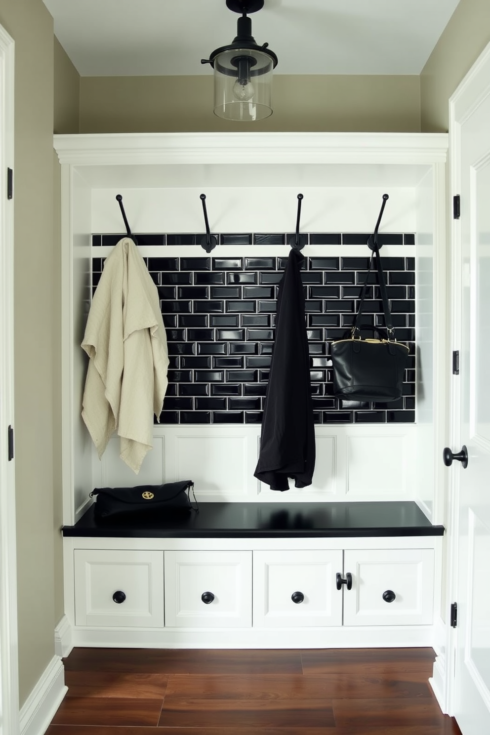 A stylish mudroom featuring a black tile backsplash that adds a touch of elegance. The space includes built-in storage benches with hooks above for coats and bags, creating a functional yet chic entryway.