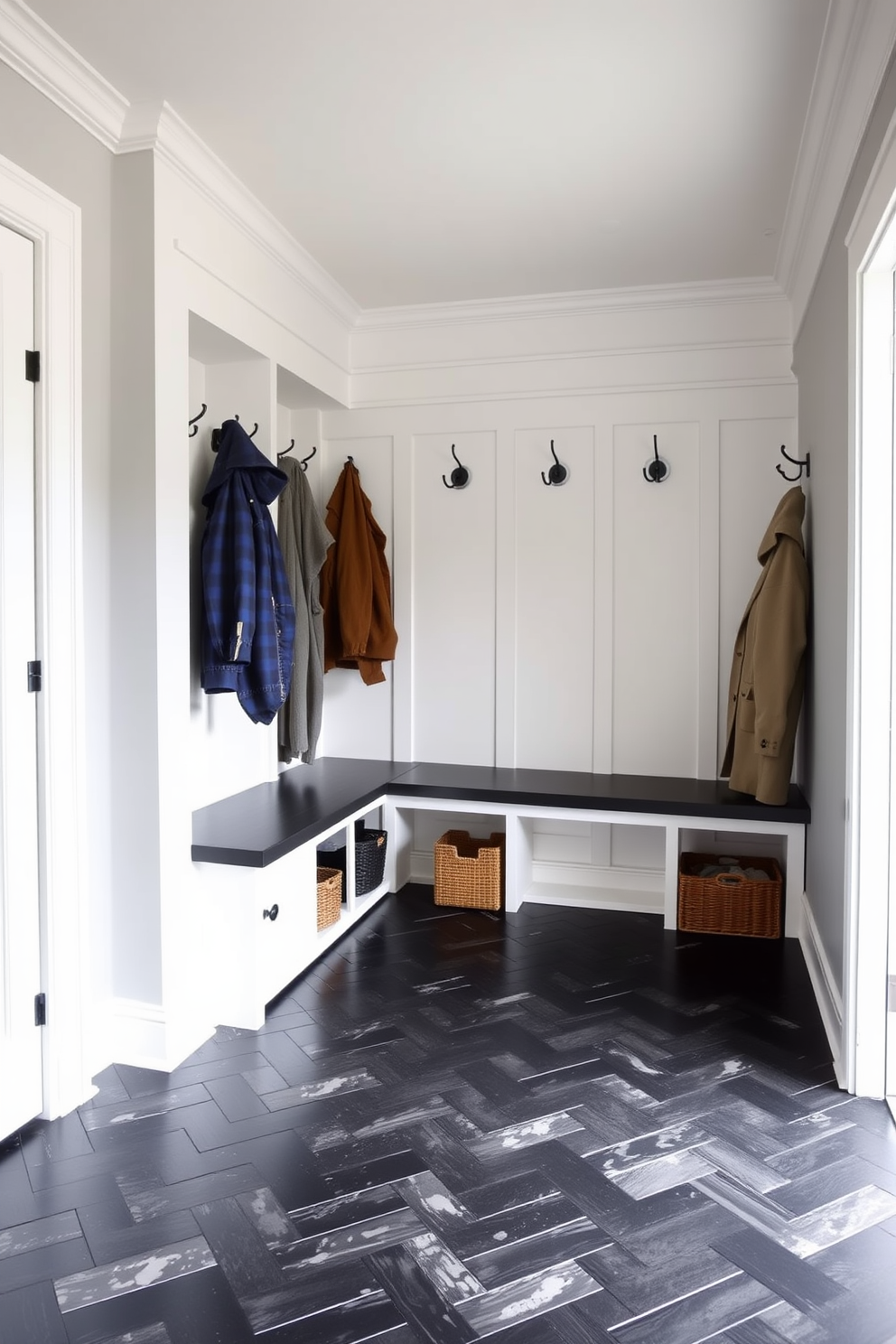 A stylish mudroom featuring a black herringbone floor complemented by crisp white trim. The space includes built-in storage benches with plush cushions and hooks for hanging coats, creating an inviting and functional entryway.