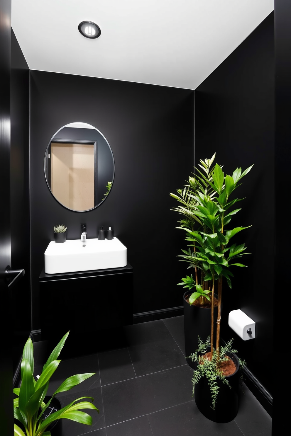 A sleek black powder room featuring minimalist decor. The walls are painted in a deep matte black, complemented by a floating black vanity with a simple white sink. Lush greenery accents are strategically placed throughout the space. A tall potted plant stands in one corner, while small succulents adorn the vanity.