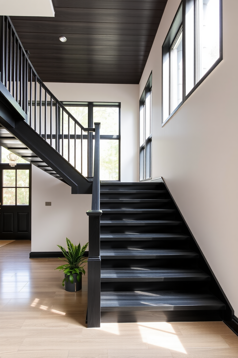 A sleek black wooden staircase with open treads creates a striking focal point in the entryway. The minimalist design features elegant railings that complement the modern aesthetic of the surrounding space. Natural light streams through large windows, highlighting the rich texture of the black wood. Underneath the staircase, a small potted plant adds a touch of greenery, enhancing the overall ambiance.