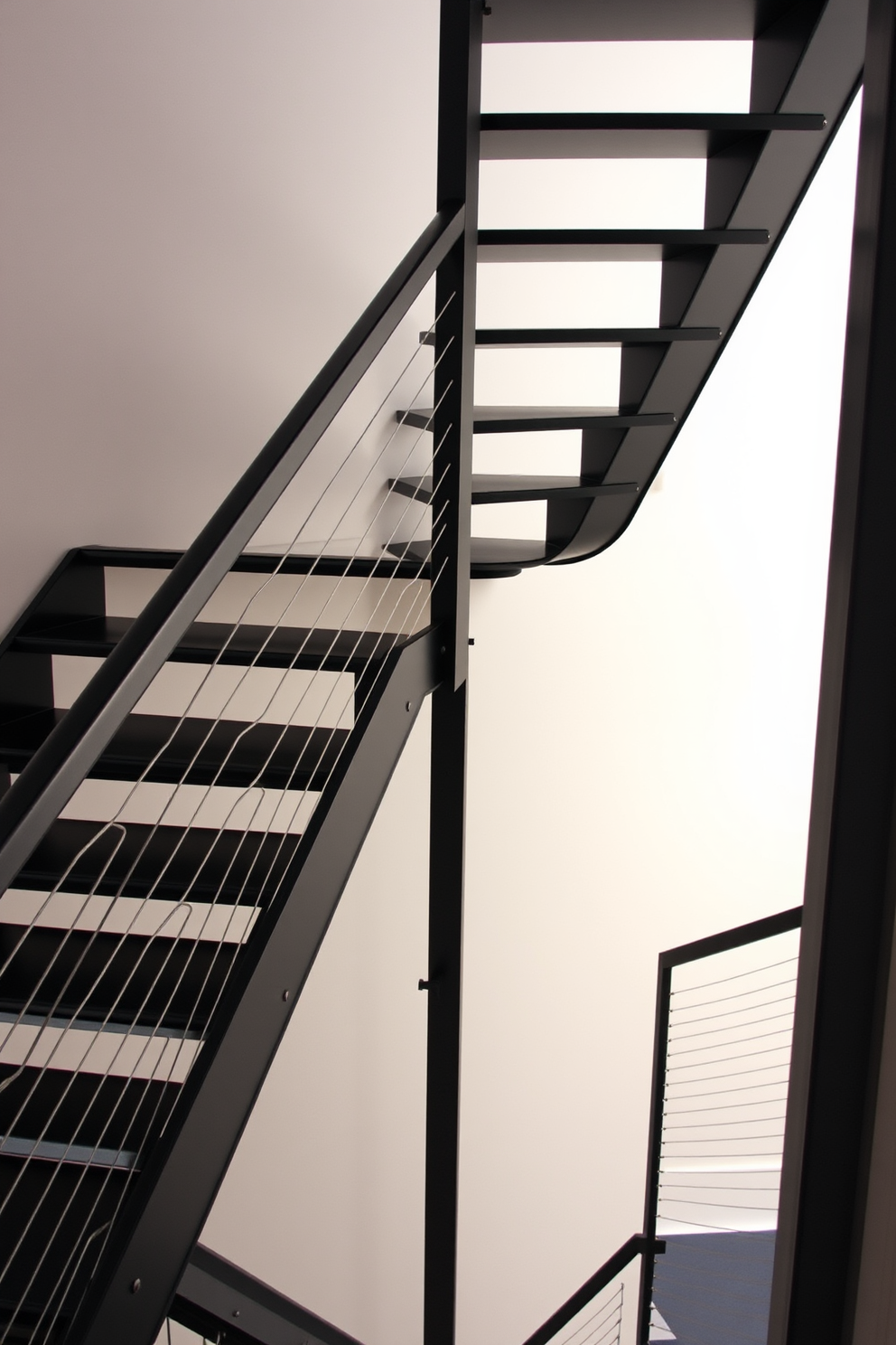 An industrial black metal staircase ascends with sleek cable railing on either side. The design features bold geometric lines and a minimalist aesthetic, perfect for a modern loft or urban space.