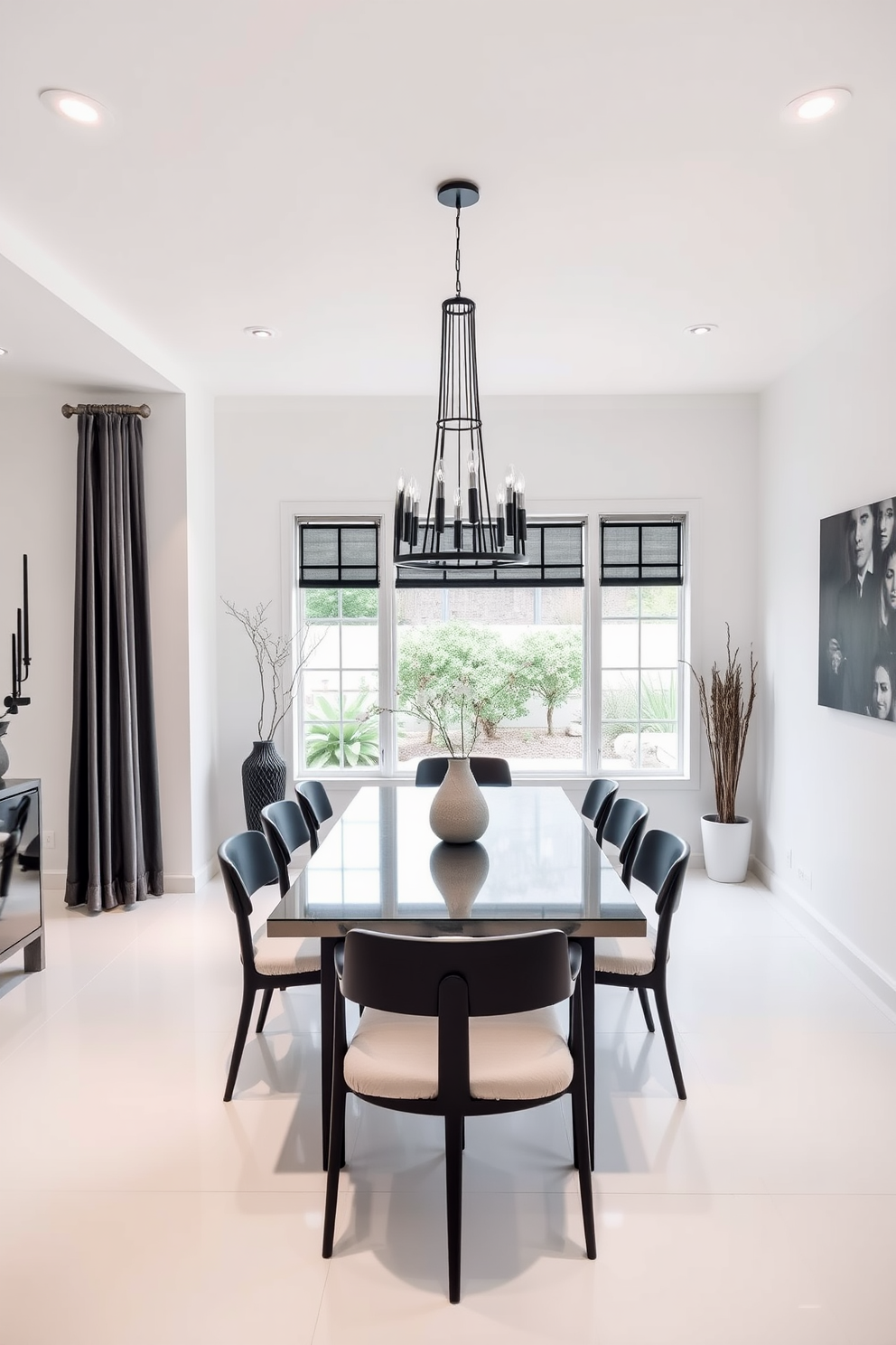 A sleek dining room featuring minimalist black dining chairs with soft cushions around a modern rectangular table. The walls are painted in a crisp white, complemented by black accents in the decor and lighting fixtures. The room showcases a harmonious blend of black and white elements, with a statement chandelier hanging above the table. Large windows allow natural light to flood the space, highlighting the elegant simplicity of the design.