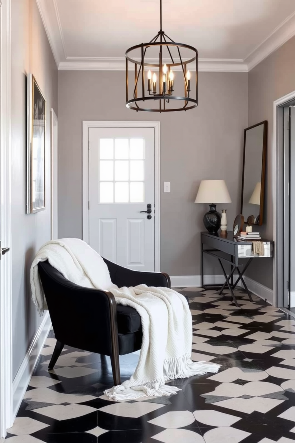 Cozy black armchair positioned in a stylish foyer adorned with a white throw draped casually over one arm. The walls are painted in a soft gray, and the floor features elegant black and white patterned tiles that enhance the inviting atmosphere. A statement light fixture hangs above, casting a warm glow across the space. Decorative elements like a sleek console table and a large mirror add depth and sophistication to the overall design.